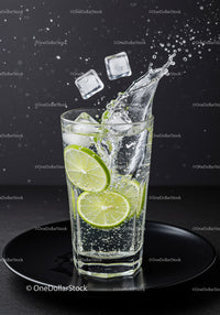 Refreshing sparkling water with lime and ice cubes splash