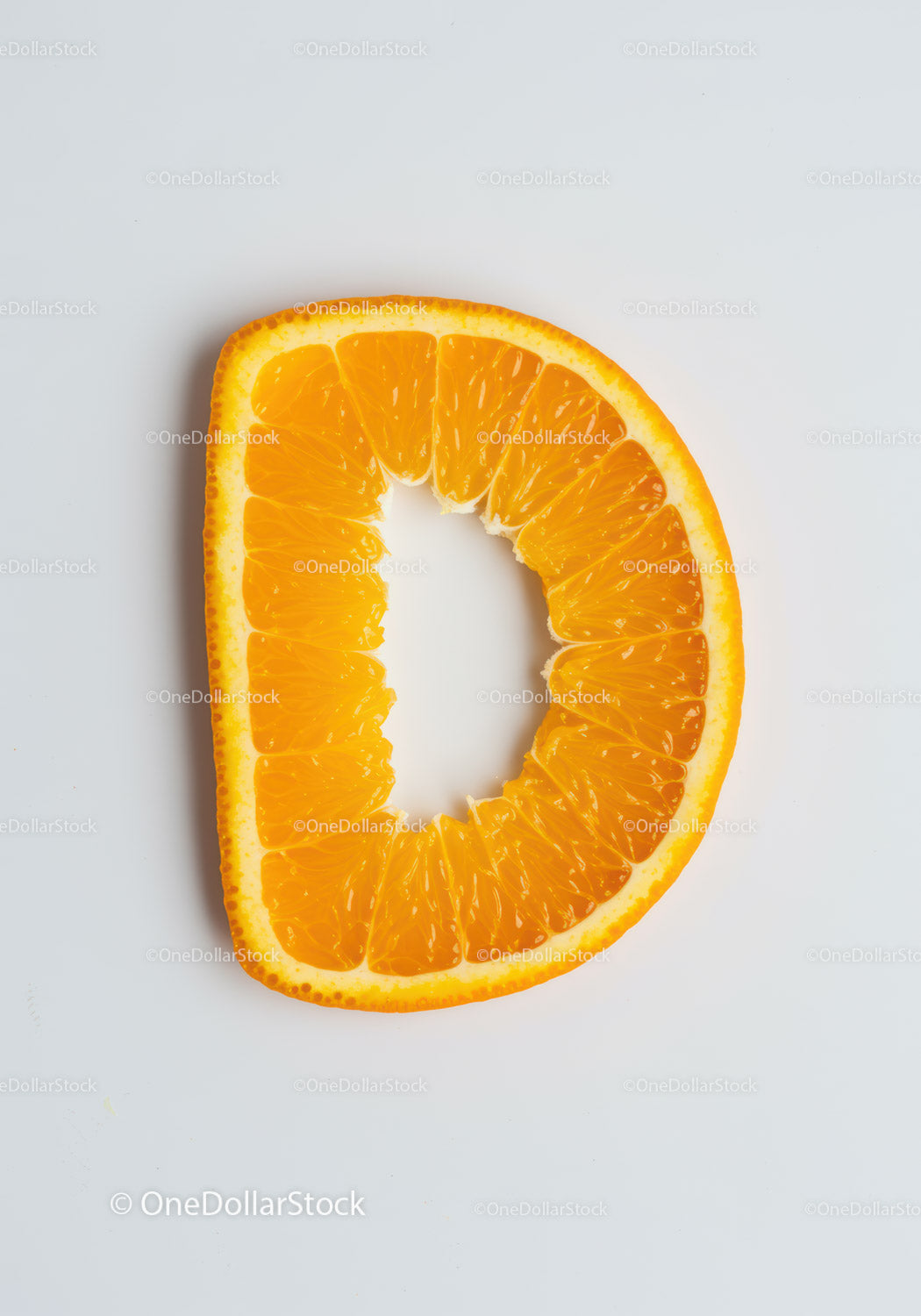 Fresh orange slice shaped like letter D on white background