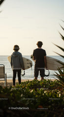 Surfers Holding Surfboards at Sunset on Tropical Beach