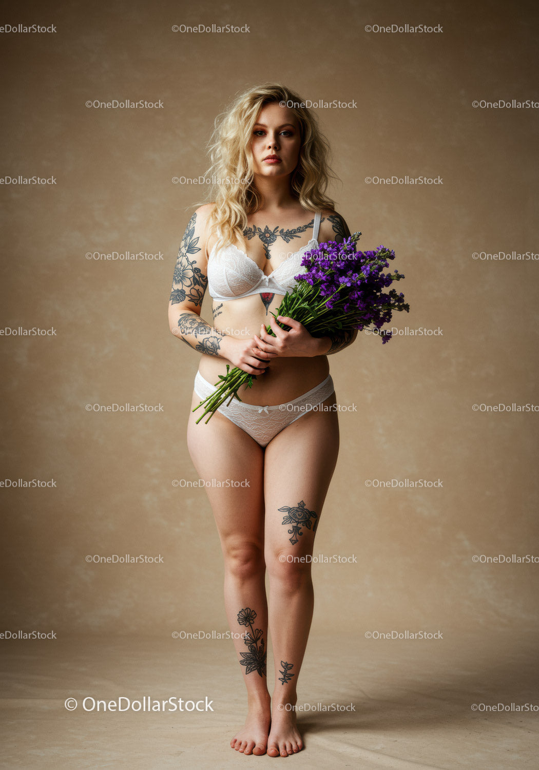 Stylish Woman with Tattoos Holding Purple Flowers in Lingerie