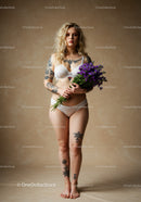 Stylish Woman with Tattoos Holding Purple Flowers in Lingerie