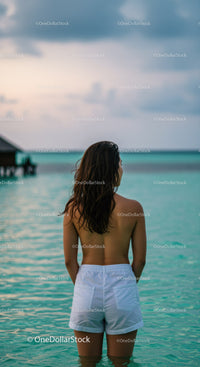 Relaxing Woman Standing in Clear Turquoise Ocean Waters at Sunset