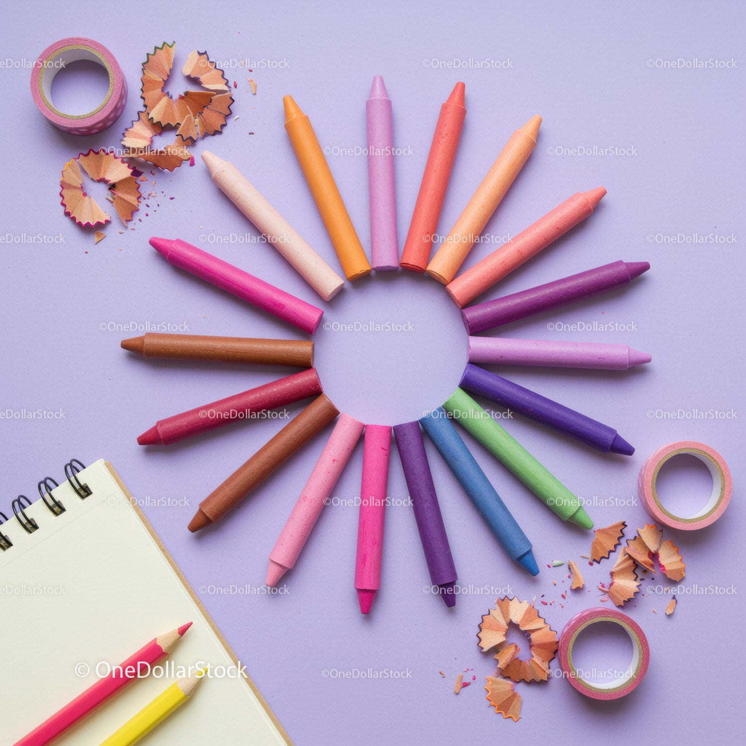 Colorful crayons arranged in circular pattern on purple background
