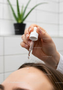 Woman Receiving Facial in Spa Setting With Cleanser and Green Plant