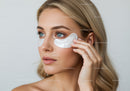 Close-up of Woman Applying Facial Moisturizer with Beautiful Blue Eyes