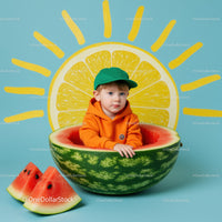 Child in Orange Hoodie Sitting Inside Watermelon Bowl