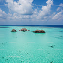 Overwater Bungalows Amidst Bright Turquoise Ocean and Blue Sky