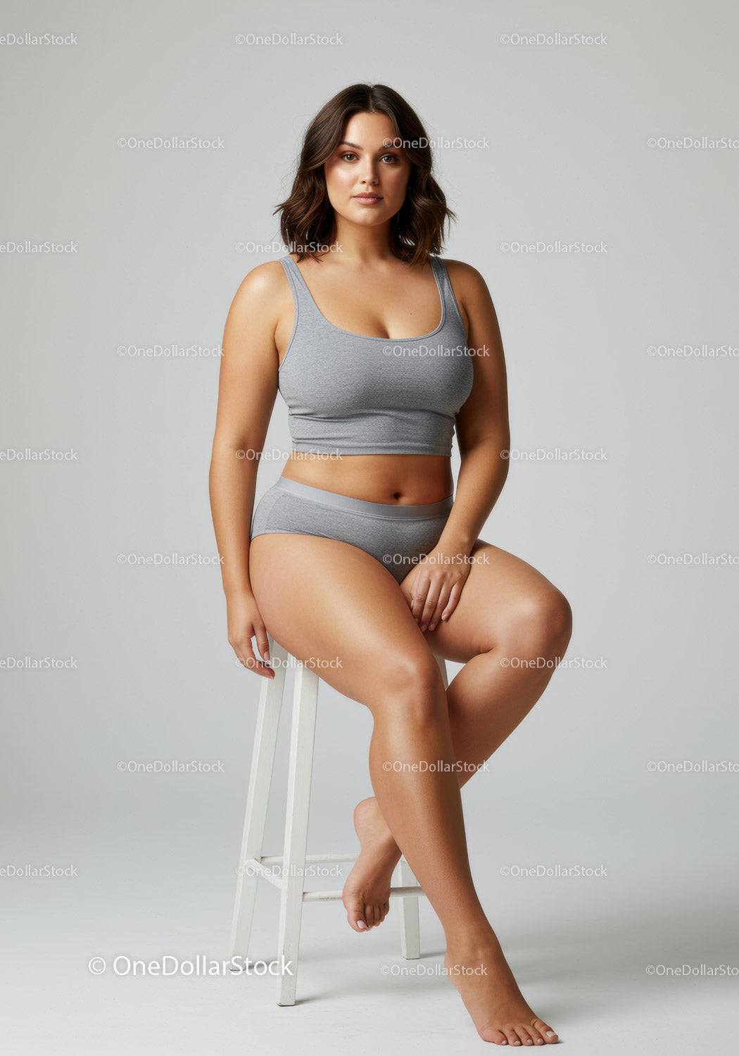 Confident Plus Size Woman Sitting on Stool Wearing Casual Gray Outfit
