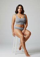 Confident Plus Size Woman Sitting on Stool Wearing Casual Gray Outfit