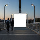 Evening joggers passing illuminated urban billboard