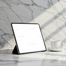 Modern tablet with blank screen on marble table with coffee