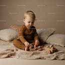 Toddler Playing with Wooden Toys on Cozy Bed