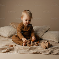 Toddler Playing with Wooden Toys on Cozy Bed