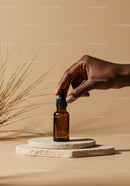 Brown Glass Dropper Bottle with Natural Serum on Minimalist Stand