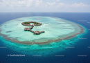 Tropical Overwater Bungalows in Clear Turquoise Ocean Surrounding an Island