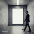 Blurred man walking past blank billboard in concrete room