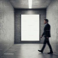 Blurred man walking past blank billboard in concrete room