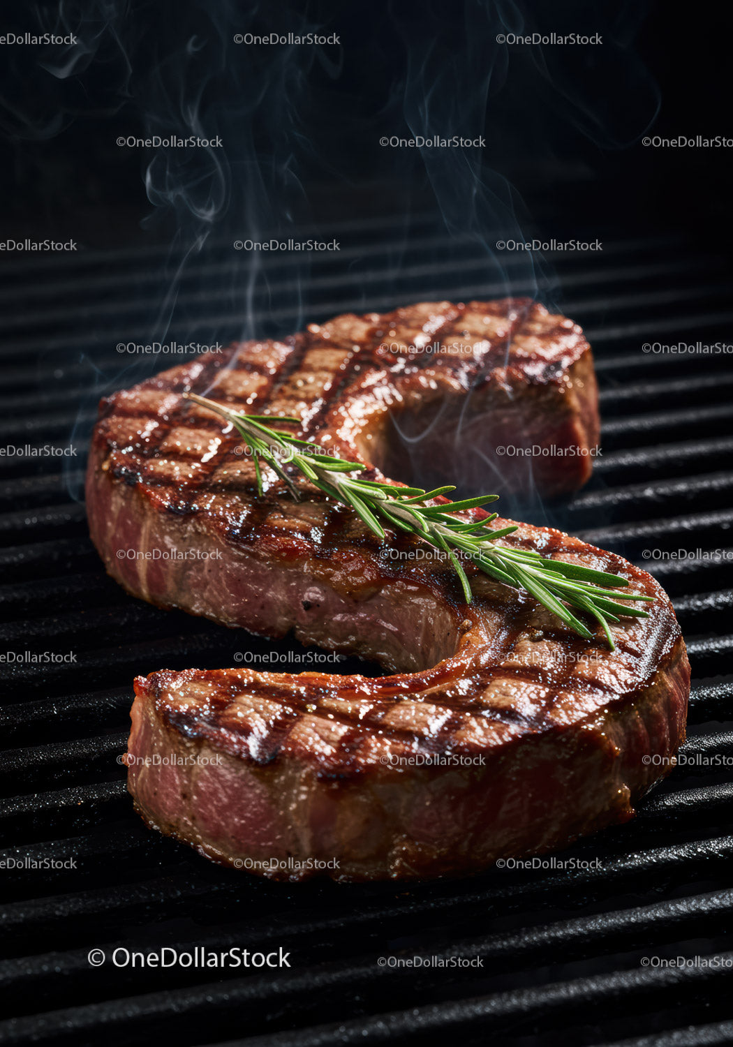 Juicy grilled steak with fresh rosemary on barbecue grill