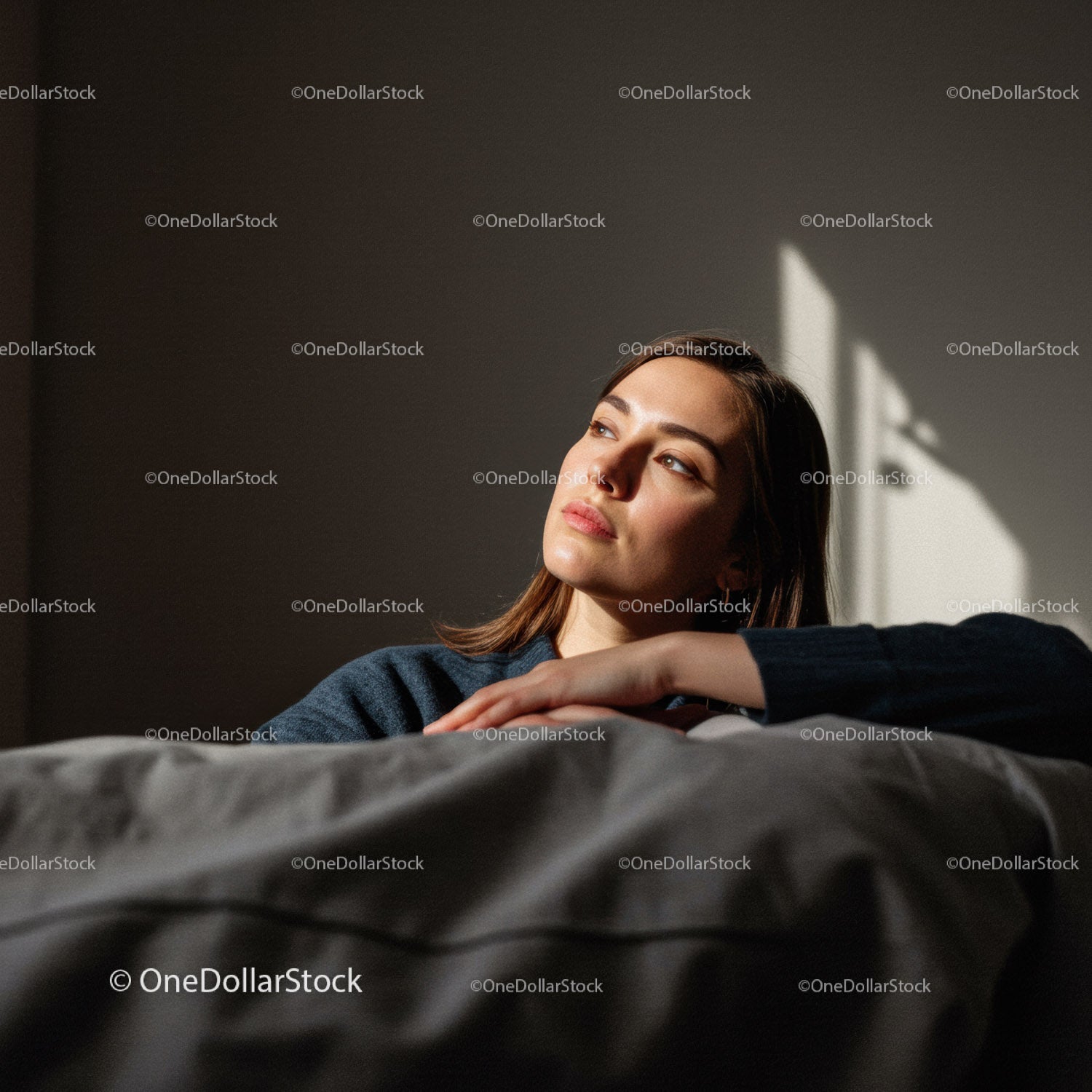 Serene Young Woman Relaxing Indoors with Sunlight Casting Shadows