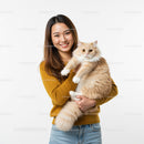 Young woman smiling with her fluffy cream cat indoors
