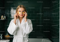 Young Woman in Spa Bathroom Applying Face Mask for Skincare Routine