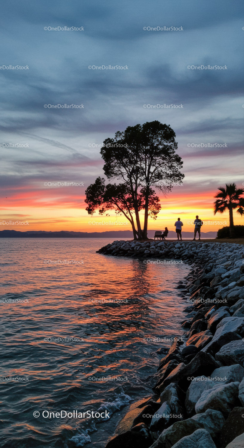 Serene Sunset Over Lake with Silhouetted Trees and People