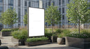 Urban courtyard with blank advertising billboard and greenery