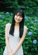 Young Woman Smiling in Garden with Blue Hydrangeas