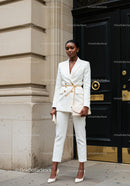 Confident woman wearing elegant white pantsuit outdoors