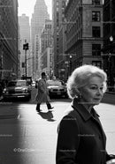 Elderly Woman in Busy City Street Surrounded by Vintage Cars