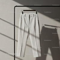 Minimalist white tailored trousers hanging on rack