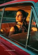 Stylish Woman Wearing Sunglasses in Vintage Car at Sunset