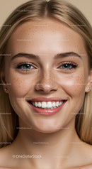 Close-up of smiling young woman with natural freckles