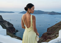 Elegant woman in yellow dress overlooking serene sea view
