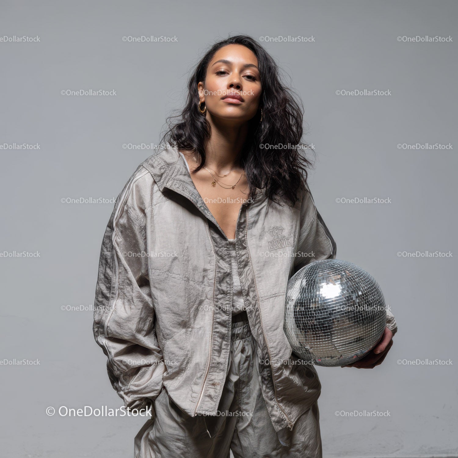 Stylish Woman in Metallic Outfit Holding Disco Ball for Modern Fashion