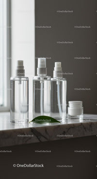 Minimalist clear cosmetic bottles on marble surface