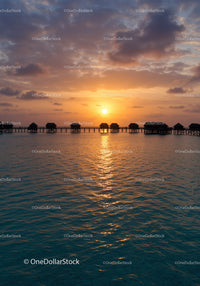 Sunset Overwater Bungalows with Colorful Sky and Calm Ocean