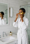 Young Woman Applying Eye Patches in Modern Bathroom For Skincare