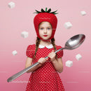 Little girl dressed as strawberry holding giant spoon