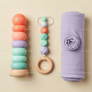 Colorful baby toys and soft swaddle on beige background