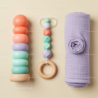 Colorful baby toys and soft swaddle on beige background