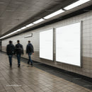 Commuters walking past empty ad boards in subway tunnel