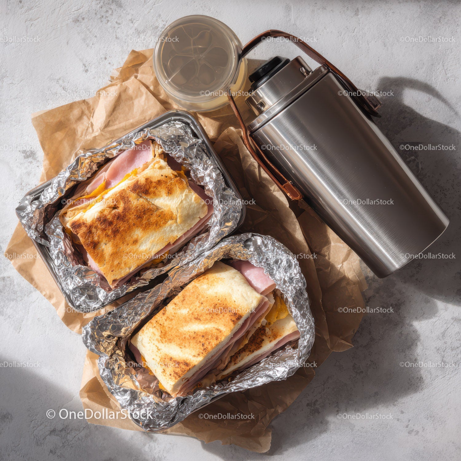Delicious Ham and Cheese Toasted Sandwiches in Foil Wrap with Drink