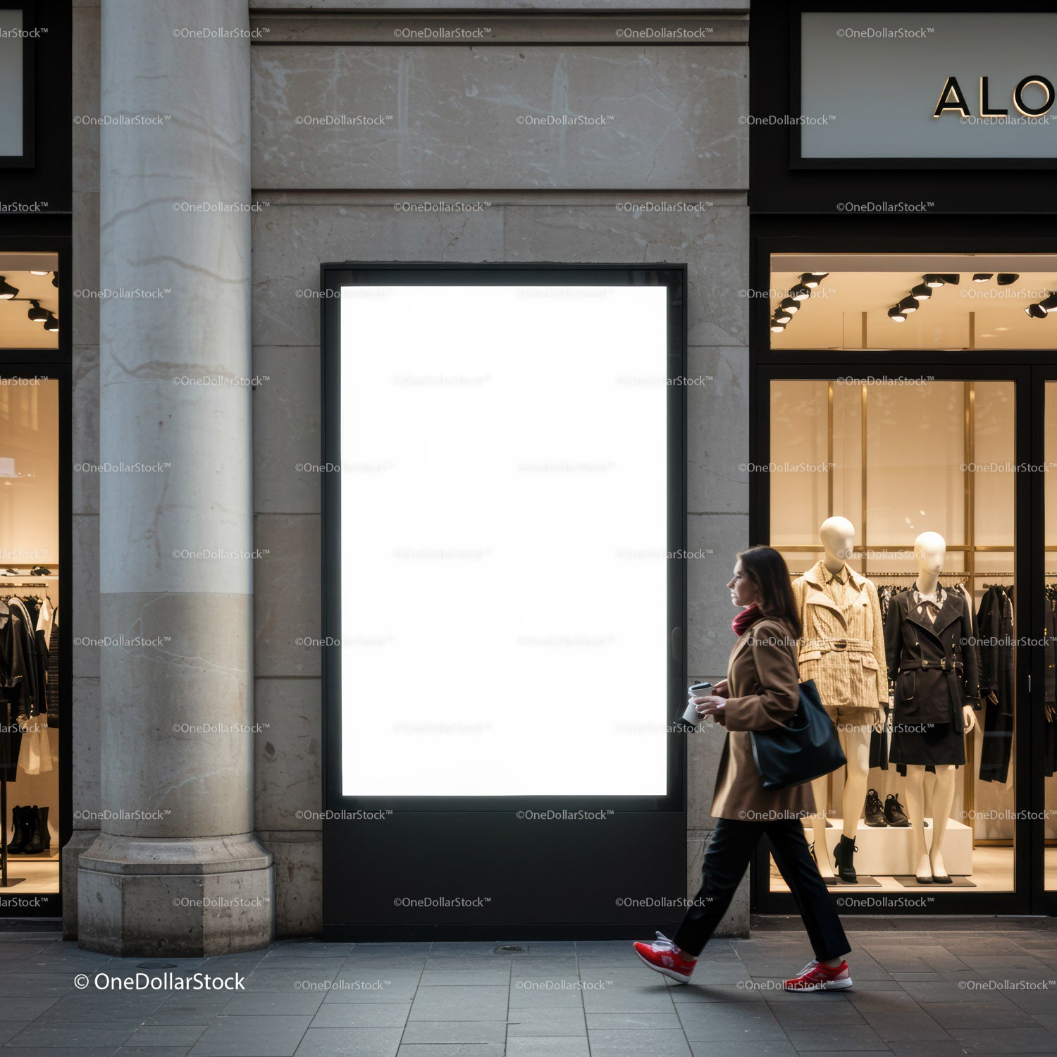 Woman walking past illuminated blank billboard in shopping district