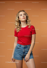 Young woman in red shirt looking thoughtfully upward