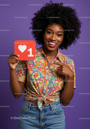 Smiling Woman Holding Heart Sign with Colorful Shirt Against Purple Background