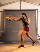 Athletic woman practicing boxing punch indoors