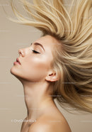 Profile of woman with flowing blonde hair against beige