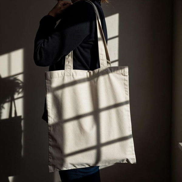Person Holding Blank Canvas Tote Bag in Natural Light JPG Mockup Image