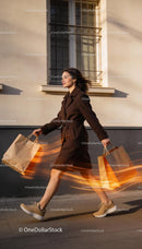 Woman in brown coat walking with shopping bags
